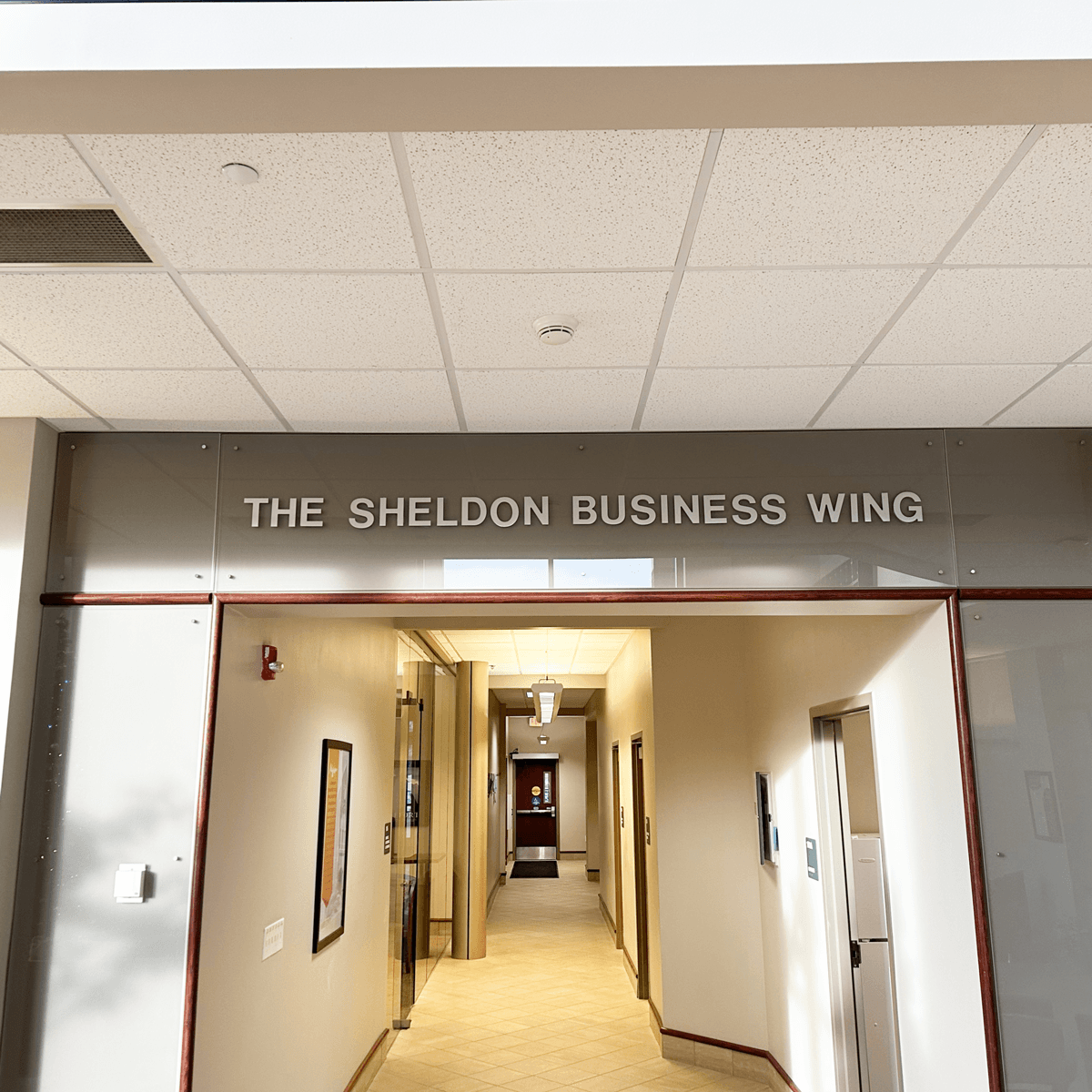 Corridor with 'The Sheldon Business Wing' sign on a wall on campus in Jamestown, ND.