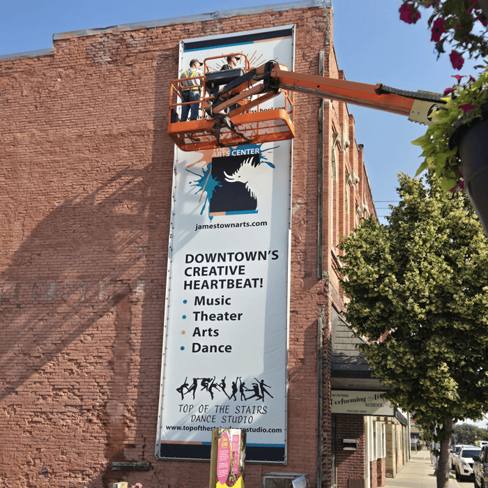Newman Print team installing large outdoor downtown banner.